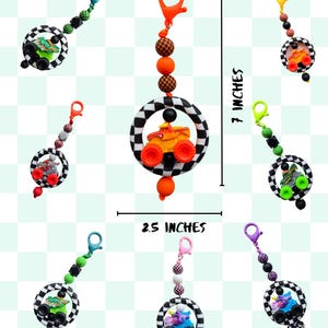 K&ouml;nnte beinhalten: Eine Sammlung farbenfroher Schl&uuml;sselanh&auml;nger, jeweils mit einem Monster-Truck-Design. Die Schl&uuml;sselanh&auml;nger sind 6,35 cm breit und 17,78 cm lang. Die Trucks sind in verschiedenen Farben gehalten, und die Schl&uuml;sselanh&auml;nger haben eine Vielzahl von Perlenfarben.