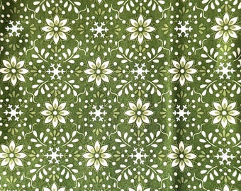 Può includere: Un tessuto verde con un motivo ripetitivo di fiori stilizzati bianchi e verde chiaro e piccoli fiocchi di neve bianchi. Il design include delicati rametti bianchi a forma di foglia e piccoli punti bianchi disposti a griglia.
