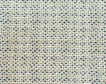 Può includere: Un tessuto con un motivo geometrico ripetitivo di piccoli rombi verdi e minuscoli punti rosso scuro disposti a griglia su sfondo bianco. Il design è composto da file alternate di forme che creano una trama visiva uniforme.