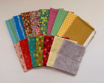 Può includere: Una collezione di campioni di tessuto piegati disposti a ventaglio, caratterizzati da una varietà di motivi tra cui forme geometriche, punti e linee astratte in colori come blu, verde, giallo, rosso, rosa e grigio con accenti dorati.