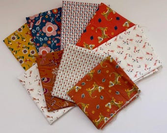 Può includere: Una collezione di quadrati di tessuto piegati con motivi diversi, tra cui tigri arancioni, piccole stampe floreali rosse, sfondi bianchi con uccelli rosa, disegni floreali giallo senape e sfondi blu scuro con grandi fiori rosa.