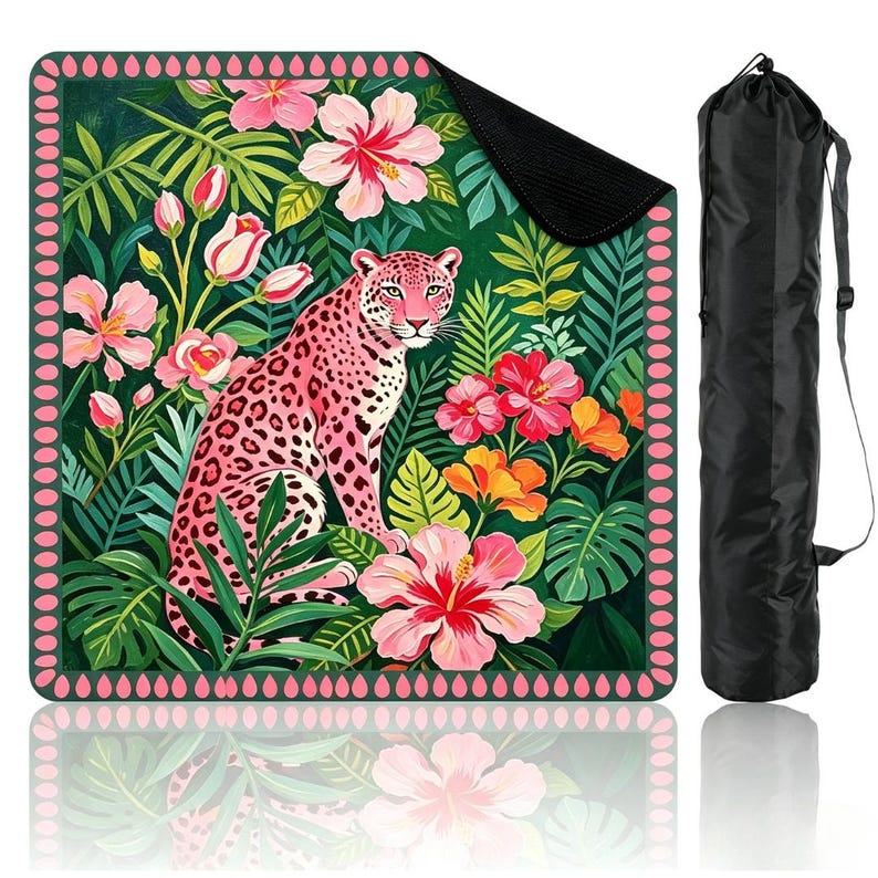 May include: A square mat featuring a pink leopard surrounded by tropical green foliage and vibrant pink, orange, and red hibiscus flowers, framed by a pink teardrop border, accompanied by a black cylindrical carrying bag with a shoulder strap.