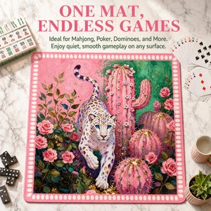 May include: A square game mat featuring a white leopard with blue eyes walking among pink cacti and roses. The border is pink with white dots. Text at the top reads ONE MAT, ENDLESS GAMES. The mat is surrounded by mahjong tiles and playing cards.