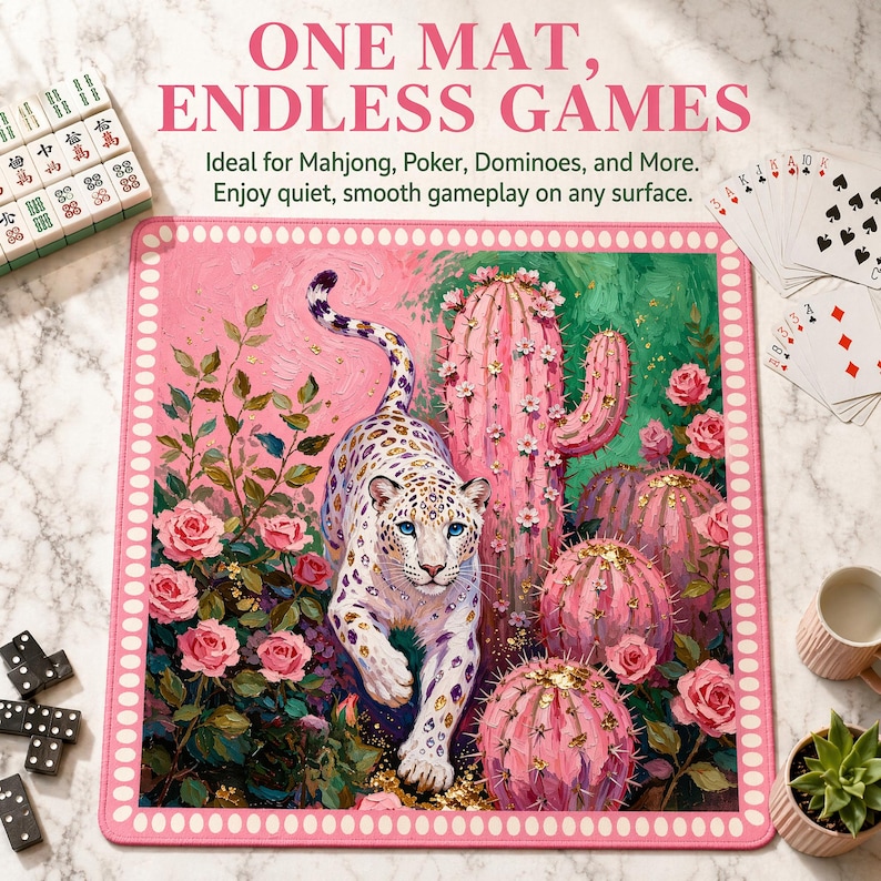 May include: A square game mat featuring a white leopard with blue eyes walking among pink cacti and roses. The border is pink with white dots. Text at the top reads ONE MAT, ENDLESS GAMES. The mat is surrounded by mahjong tiles and playing cards.