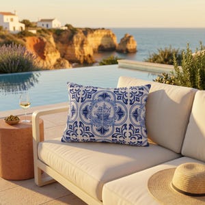 May include: A rectangular throw pillow featuring a blue and white pattern inspired by traditional ceramic tiles. The design includes intricate floral motifs and a central circular illustration of a sailing ship on the ocean waves.