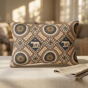 May include: A rectangular throw pillow featuring a repeating geometric pattern in navy blue, cream, and tan. The design includes circular sunburst motifs with the IHS monogram and diamond-shaped panels depicting the Capitoline Wolf with twins.