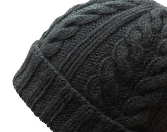 May include: A black knitted beanie with a cable knit pattern. The beanie is made of a soft, warm material and has a fold-over brim.