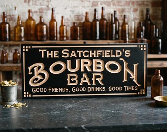 May include: A rectangular black wooden sign with carved, light-colored lettering that reads: The Satchfield's BOURBON BAR, GOOD FRIENDS, GOOD DRINKS, GOOD TIMES. The sign features decorative square corner accents and a smooth finish.