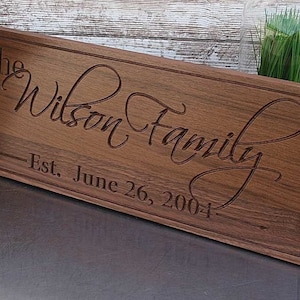 May include: A wooden sign with the text "The Wilson Family - Est. June 26, 2004" in a cursive font.