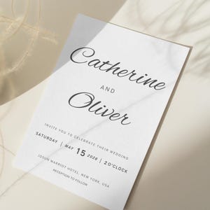 Puede incluir: Una invitación de boda blanca con una elegante escritura en negro. El texto dice "Catherine y Oliver" encima de los detalles de la invitación. La invitación incluye la fecha, la hora y el lugar de la boda: Josun Marriot Hotel, Nueva York, EE. UU.