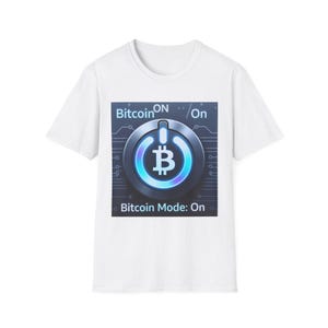 May include: White t-shirt featuring a graphic with a Bitcoin symbol inside a power button design. The text "Bitcoin ON / On" is above the button, and "Bitcoin Mode: On" is below. The design has blue and silver tones.