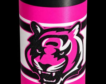 May include: A cylindrical beverage cooler featuring a vibrant hot pink base with a black rim. A central white horizontal band is accented by thin black stripes. A raised, textured black and hot pink tiger head graphic is centered on the front.