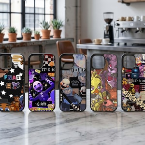 Puede incluir: Cinco fundas negras para teléfono con varios diseños. Una funda tiene el texto "FNAF" con estrellas y personajes de dibujos animados. Otra presenta una marioneta morada con el texto "IT'S ME" y "6 AM". Otras fundas tienen diseños de collage.