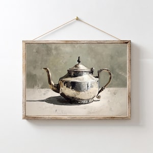 May include: A framed print of a silver teapot with a curved spout and ornate handle. The teapot is set against a neutral background, with a wooden frame and a hanging string.