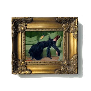 May include: A framed painting depicts a woman in a black dress reclining on a green sofa. The ornate gold frame surrounds the artwork, which features a book and pillows. The woman has red hair.