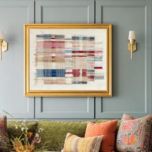 May include: A rectangular wall art piece featuring a woven textile design with horizontal and vertical stripes in shades of red, blue, beige, and white, encased in a thick, polished gold frame with a classic, ornate profile and beveled edges.
