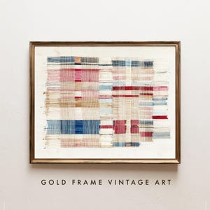 May include: A rectangular wall art piece featuring a woven textile design with horizontal and vertical threads in shades of red, blue, beige, and white, encased in a thin gold-colored metal frame against a plain off-white background.