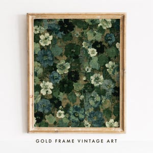 Peut inclure: Une impression d'art mural encadrée présentant un motif floral dense avec des fleurs superposées dans des tons de vert forêt, sauge, bleu marine et crème. L'œuvre est insérée dans un cadre en bois clair au grain visible, affichant un motif botanique.