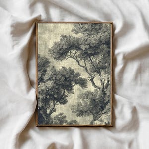 Op de afbeelding: Een rechthoekige wandkunstprint met een donker antracietgrijze inktillustratie van dichte, bladerrijke bomen tegen een getextureerde, lichtbeige achtergrond. Het kunstwerk is gevat in een dunne, middelbruine houten lijst met een strakke rand.