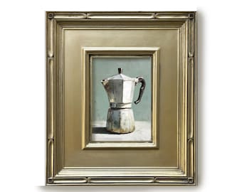 May include: A framed painting depicting a silver moka pot with a dark handle, set against a light green background. The painting is encased in a wide, ornate gold-colored frame with a multi-layered, stepped border design and a polished finish.