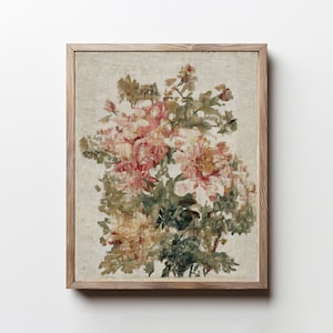 May include: A framed floral print featuring a bouquet of pink, yellow, and green flowers. The artwork is set against a neutral background and encased in a light brown wooden frame, creating a vintage aesthetic.