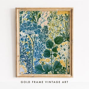 Peut inclure: Une impression d'art murale rectangulaire encadrée dans un cadre en bois brun clair. L'œuvre présente un motif botanique dense avec diverses fleurs et feuillages dans des tons de bleu profond, vert forêt, jaune moutarde et crème sur fond clair.