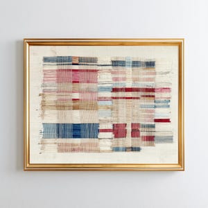May include: A framed textile wall art piece featuring a grid of woven threads in shades of red, blue, and beige. The composition consists of horizontal and vertical lines creating a textured, layered appearance within a thin gold-colored frame.