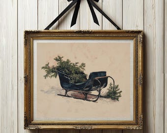 May include: A framed print featuring a dark blue sleigh carrying green pine branches, set against a light beige background. The artwork is enclosed in an ornate gold frame and is suspended by a black ribbon tied in a bow at the top center.
