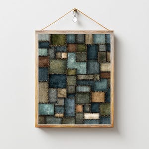 May include: A framed artwork featuring a patchwork design. The artwork is composed of various fabric squares in shades of blue, green, and brown, stitched together with visible seams. The frame is a light wood color, and the artwork is suspended by a string.