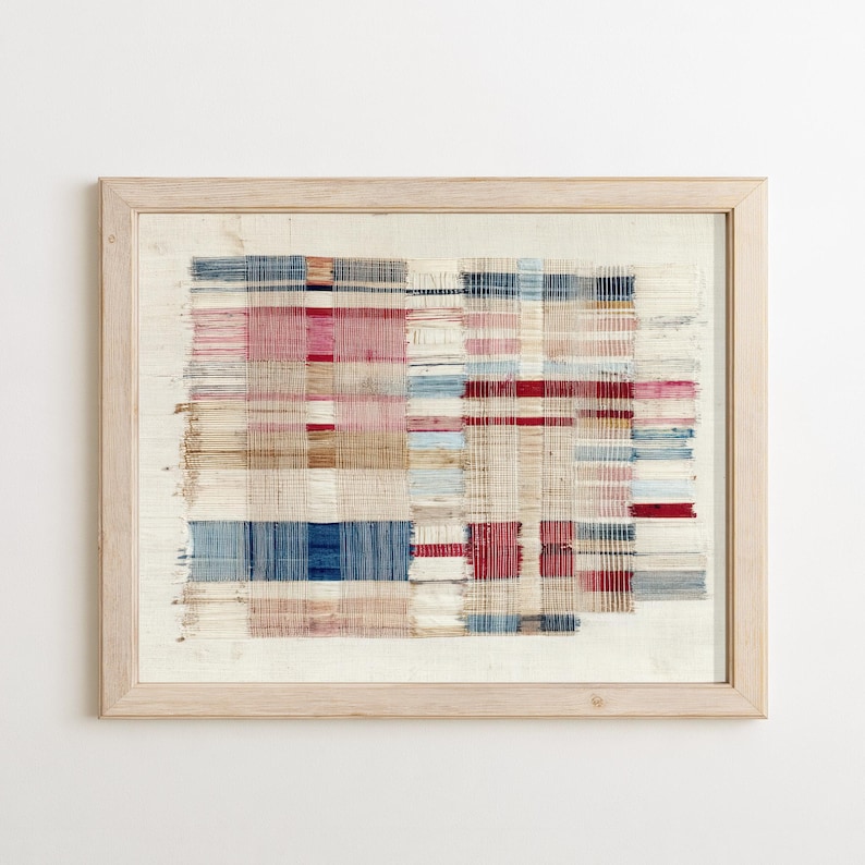 May include: A framed textile wall art piece featuring a woven grid pattern with horizontal and vertical threads in shades of red, blue, beige, and white. The design displays a loose, frayed appearance with visible thread ends and a light wood frame.