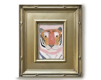 May include: A framed painting of a tiger head featuring orange, black, and white fur markings with a prominent pink nose and neck area. The artwork is encased in a rectangular, metallic gold frame with a multi-layered, stepped border design.