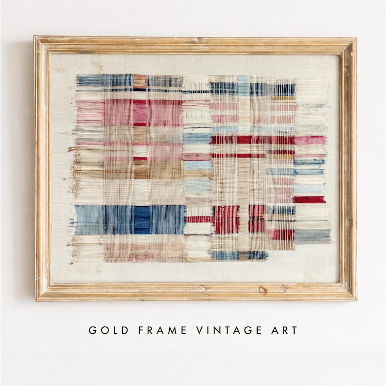 May include: A rectangular wall art piece featuring a woven textile with a grid pattern of red, blue, and beige threads, displayed within a light-colored wooden frame. The fabric shows frayed edges and a layered, textured appearance with visible vertical and horizontal thread intersections throughout the composition.