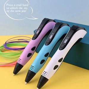 May include: Three 3D printing pens in lavender, light blue, and white with black accents, each featuring a small digital display, control buttons, and a nozzle. A speech bubble above contains the text: Press a small hand to unlock the joy of the same year.