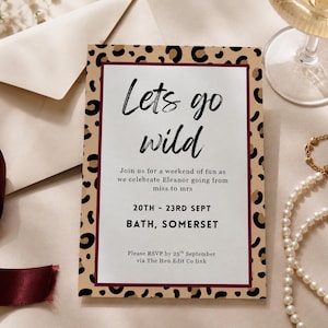 Pode incluir: Um convite para uma festa com uma borda de estampa de leopardo e as palavras "Lets go wild" em escrita preta. O convite inclui detalhes do evento e um pedido de RSVP. Uma fita bordô, um envelope e um colar de pérolas também são visíveis.