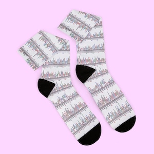 May include: A pair of white crew socks featuring a repeating DNA sequencing chromatogram pattern with multicolored peaks and black text sequences. The socks have solid black heels and toe sections, providing a distinct contrast to the scientific print.