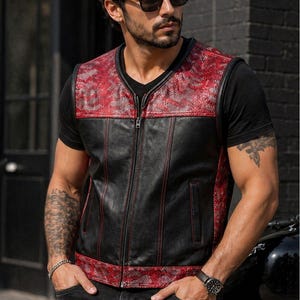 May include: A sleeveless waistcoat featuring a black leather centre panel with red stitching, accented by red and black snakeskin-textured panels on the upper chest and lower hem. The waistcoat includes a full-length front zip and two vertical side pockets.