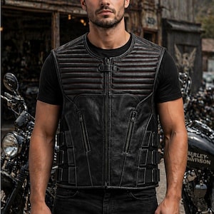 Male rider wearing a black leather motorcycle vest with horizontal padded chest panels, zip pockets and adjustable side straps.