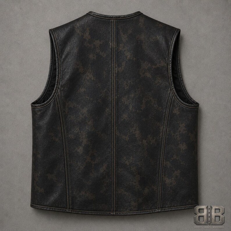 Back view of a distressed dark camo motorcycle vest with a center seam and curved side panel stitching.