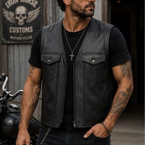 Male rider wearing a classic black leather club style vest with V-neck front, zip closure and flap chest pockets.