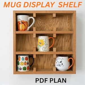 May include: Wooden mug display shelf with four decorative mugs. The mugs feature pumpkin, sunflower, and Snoopy designs. The shelf has the text "MUG DISPLAY SHELF" and "PDF PLAN" in orange.