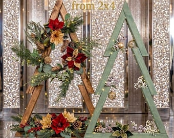 May include: Two triangular wooden Christmas tree frames. The left frame is dark brown wood decorated with red and gold poinsettias, pinecones, and greenery. The right frame is sage green wood with gold ornaments and white floral accents. Text reads: DIY Wood Christmas Tree Plans from 2x4 and PDF PLAN.
