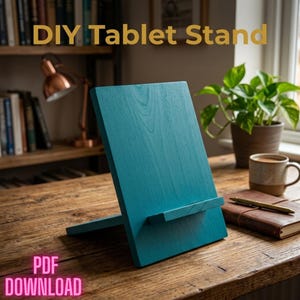 May include: A teal wooden tablet stand with a rectangular back panel and a horizontal ledge for support. The text DIY Tablet Stand is visible at the top, and the text PDF DOWNLOAD is visible at the bottom of the image.
