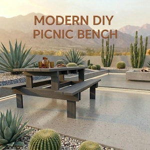 Puede incluir: Banco de picnic de madera gris con asientos adjuntos. El banco está al aire libre, rodeado de plantas del desierto y un fondo montañoso. El texto "MODERN DIY PICNIC BENCH" se muestra encima del banco.