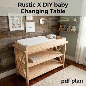 Op de afbeelding: Een lichtgekleurde houten aankleedtafel met een X-frame ontwerp. De tafel heeft een aankleedkussen bovenop en twee planken eronder. De tekst "Rustic X DIY baby Changing Table" en "pdf plan" zijn zichtbaar.