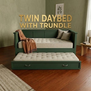 May include: A green twin daybed with a trundle, featuring a beige mattress and a brown throw blanket. The daybed has a matching trundle bed underneath. The text "TWIN DAYBED WITH TRUNDLE" is displayed above the bed.