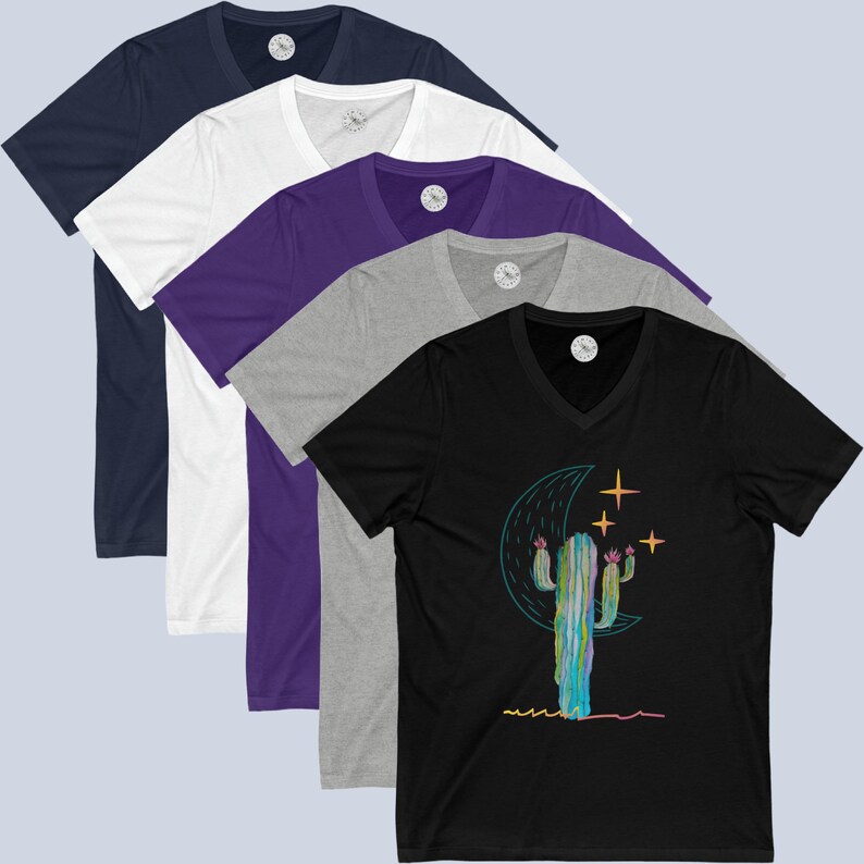 May include: Five V-neck t-shirts in different colors, featuring a graphic of a cactus with a crescent moon and stars. The colors are navy blue, white, purple, gray, and black.