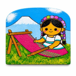 Puede incluir: Una pintura colorida representa a una figura sonriente tejiendo en un telar. La figura lleva un vestido blanco con rayas azules y una diadema floral. Una montaña está en el fondo, y la escena está ambientada en un campo de hierba verde bajo un cielo azul.