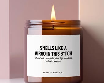 Pode incluir: Uma vela acesa num frasco de vidro âmbar com um rótulo branco. O texto diz: SMELLS LIKE A VIRGO IN THIS B*TCH, infused with color-coded plans, high standards, and quiet judgment, BY CARA CO. CANDLE | 9OZ. A vela tem um pavio a arder.