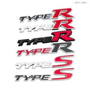 Puede incluir: Una colección de emblemas automotrices, incluyendo diseños "TYPE R" y "TYPE S". Los emblemas presentan una variedad de combinaciones de colores, incluyendo rojo, negro y plateado, con un acabado brillante. El texto "Hand Made" está en la esquina superior derecha.