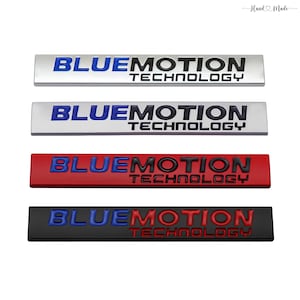 Könnte beinhalten: Vier rechteckige Autoembleme mit dem Text "BLUEMOTION TECHNOLOGY". Die Embleme sind in Silber, Rot und Schwarz gehalten. Die Textfarbe variiert zwischen Blau, Schwarz und Rot. In der oberen rechten Ecke des Bildes steht der Text "Hand Made".
